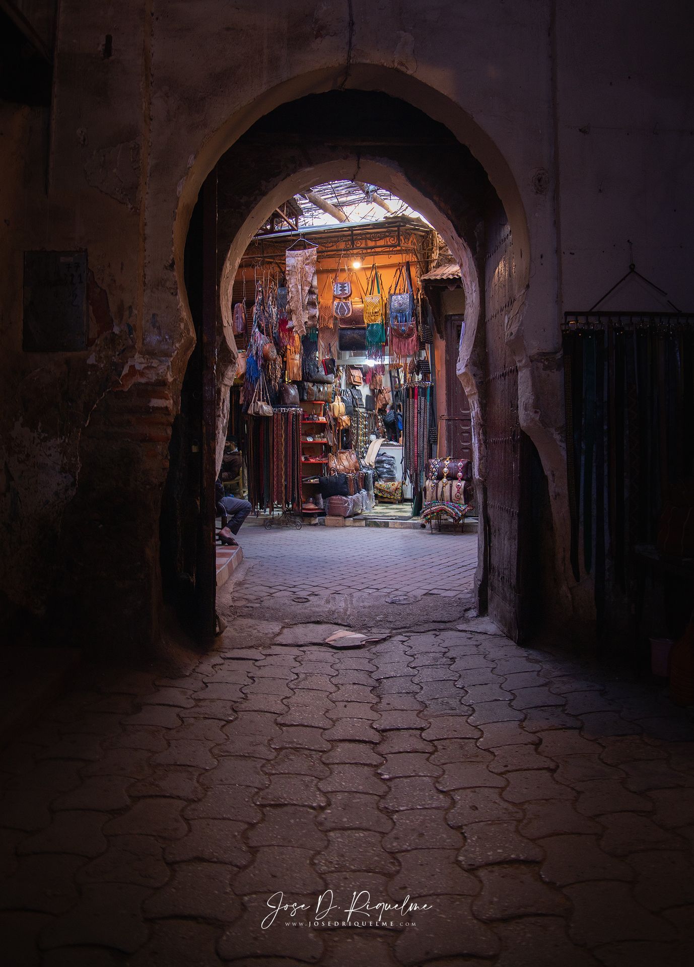 Arched doorway in the Marrakech medina opening onto a shop full of coloured leather bags